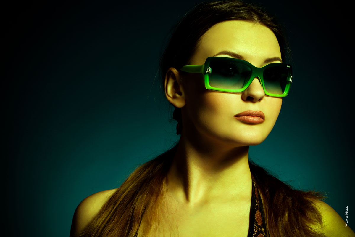 Горизонтальный модный фото портрет девушки в студии в солнечных очках