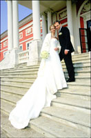 Фотография жениха, невесты и длинного шлейфа свадебного платья на ступенях дворца усадьбы Кусково в Москве