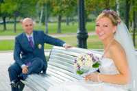 Фото свадебной пары на лавочке в парке у Новодевичьего монастыря в Москве