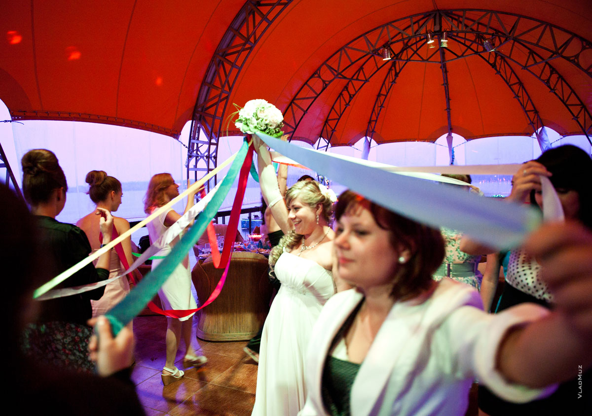 Девушки водят хоровод вокруг невесты, чтобы получить ее букет
