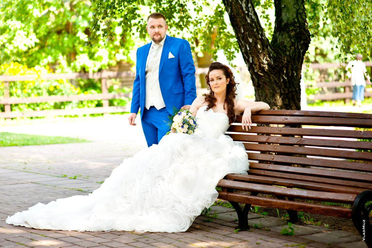 Свадебное фото жениха и невесты на скамье в парке