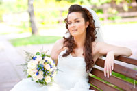 Фото невесты с букетом, сидящей на скамье
