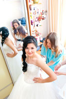 Здесь подружки затягивают невесте корсет на свадебном платье