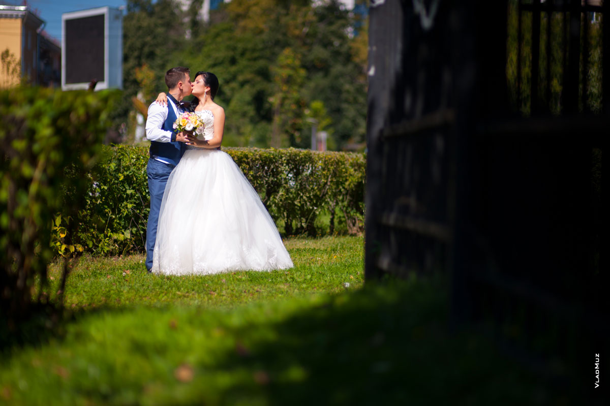 Поцелуй жениха с невестой во время свадебной прогулки