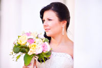 Фотопортрет невесты с букетом на фоне белых колонн в светлых тонах