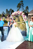 Жених с невестой устанавливают розу в вазу