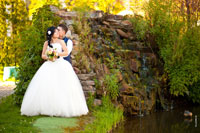 Фото свадебной пары на берегу на фоне водопада