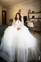 Фото невесты, свадебного платья и свадебного стилиста с фатой сзади