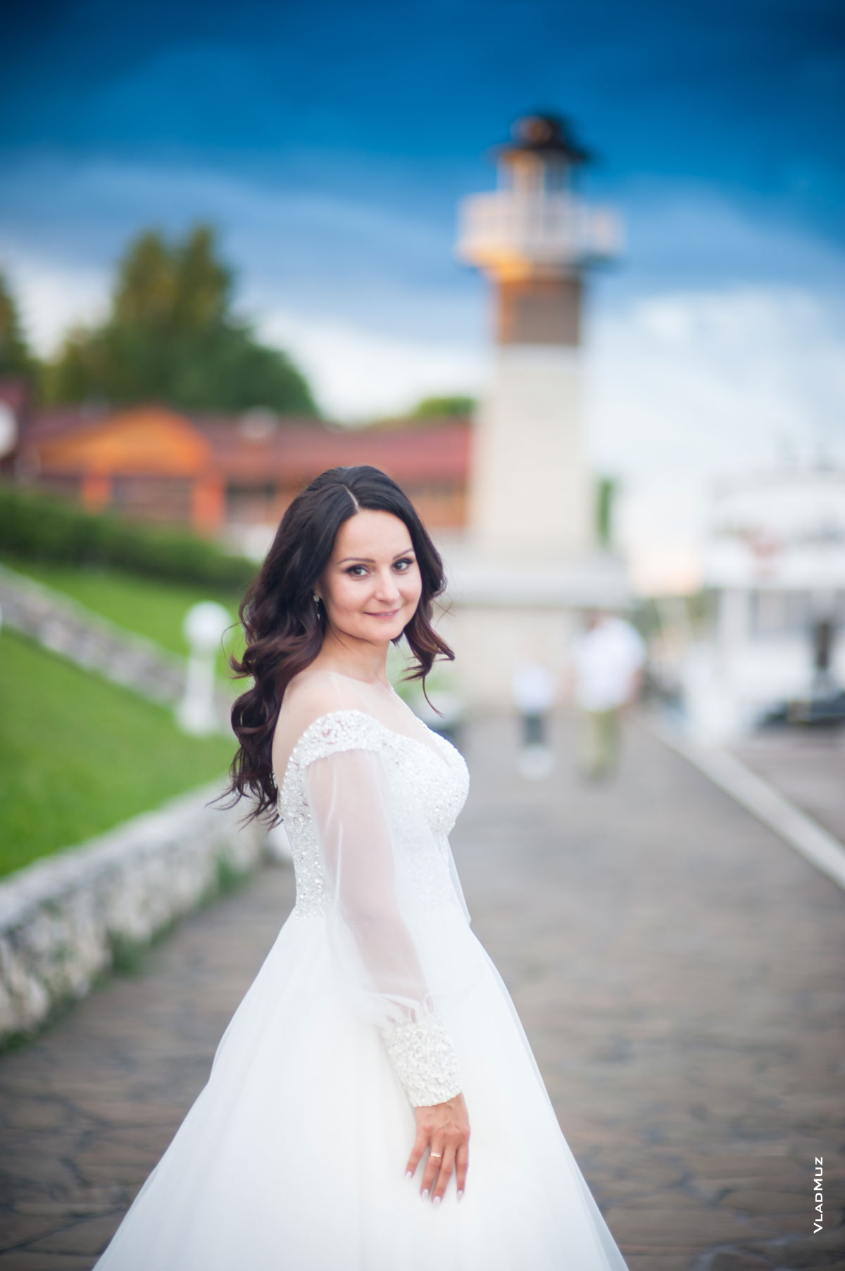 Фото невесты на фоне синего неба и маяка