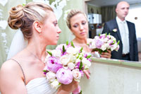 Фото невесты с букетом у зеркала, ее отражение и отражение жениха вдали