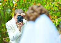 Фото жениха с фотокамерой перед невестой
