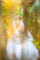 Фото невесты сквозь ограду из прутьев в саду