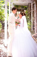 Красивое фото свадебной пары в полный рост в тенистой аллее ботанического сада