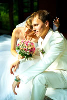 Фото жениха с невестой в солнечных лучах, сидя на террасе ботанического сада