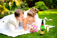 Светлый свадебный лайфстайл: жених с невестой смеются, дополняют картину букет невесты и шампанское с бокалами