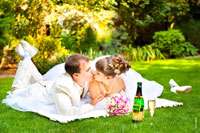 Фото свадебного поцелуя молодоженов на лужайке ботанического сада Толоконникова