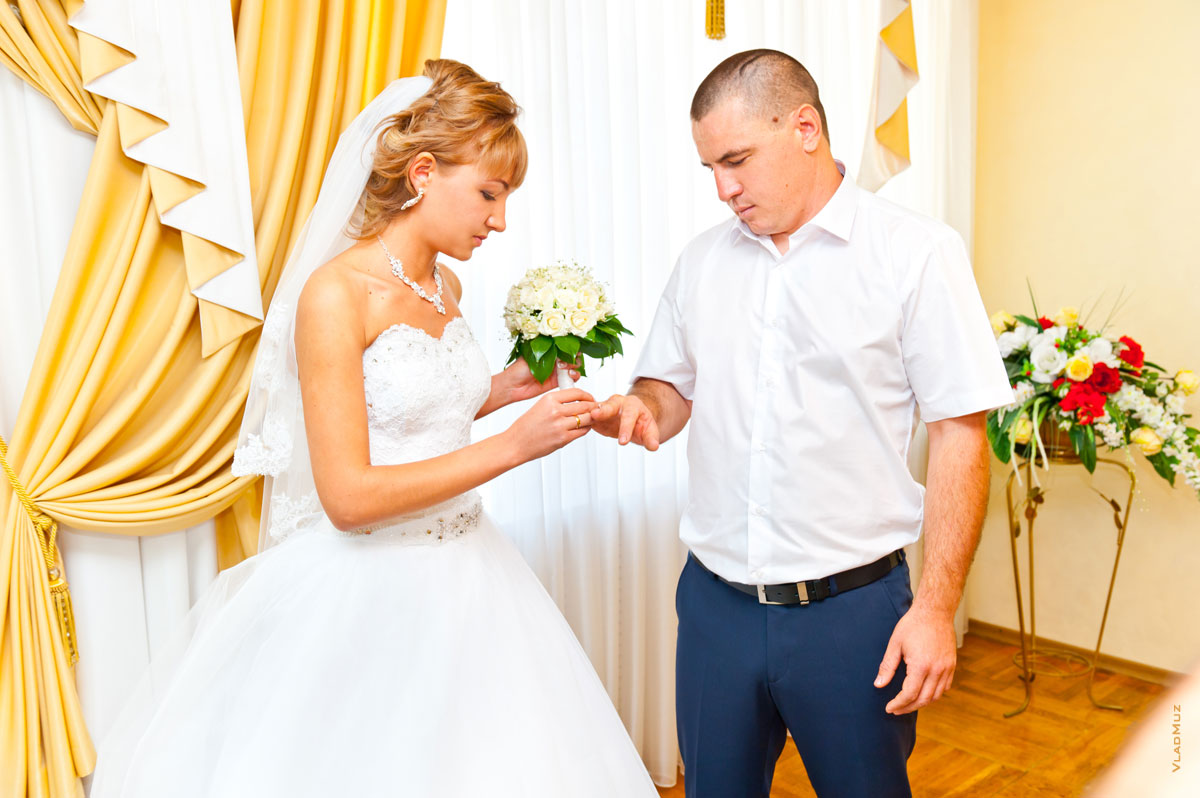 Фото невесты, надевающей обручальное кольцо жениху