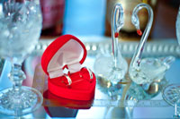 Свадебный натюрморт: обручальные кольца в коробочке, бокалы и хрустальные лебеди на подносе
