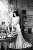 Черно-белое фото невесты в свадебном платье у стола в полный рост