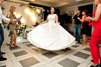 Фото танцующей невесты со шлейфом свадебного платья среди гостей