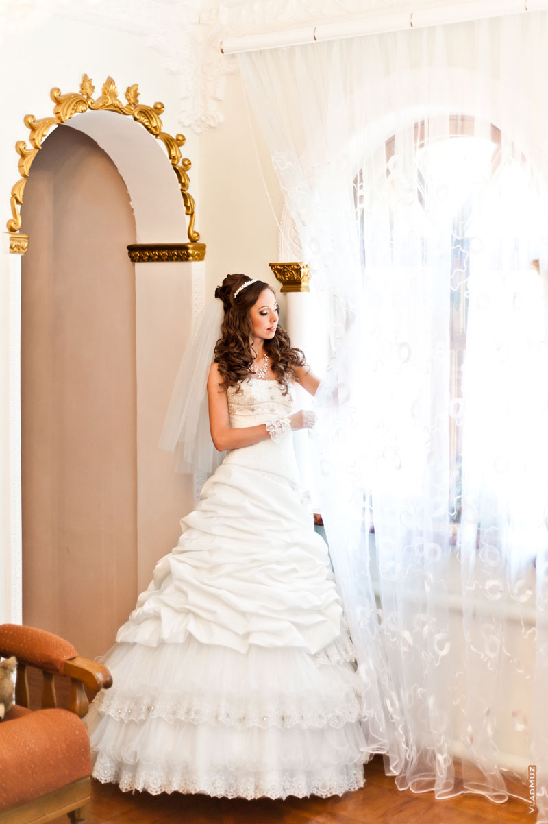 Фотография невесты у окна в ожидании жениха