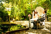 Фото сидящей свадебной пары у пруда с удочкой