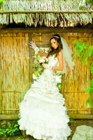 Фото невесты в саду у плетенной стены из камыша