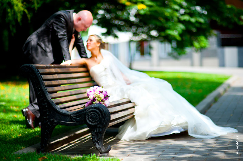 Фото букета невесты в фокусе, жениха и невесты в расфокусе на максимально открытой диафрагме 1.4 выполнено с помощью Nikon 85mm f/1.4D AF