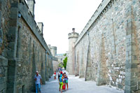 Фото каменных средневековых стен и башен Шуваловского проезда Алупкинского дворца из камня диабаза