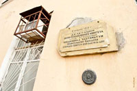 Фото таблички на здании училища связи и металлической круглой печати с надписью «Нивелировка г. Новочеркасска, 1916»