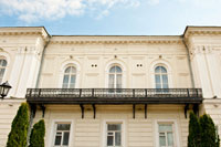 Фото балкона на 2-м этаже Атаманского дворца в Новочеркасске, декоративной решетки, пилястр по бокам, розеток и львиных барельефов на дворцовом фасаде