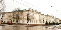 Большое белое старинное 2-этажное здание на пересечении проспекта Ермака и улицы Просвещения в Новочеркасске