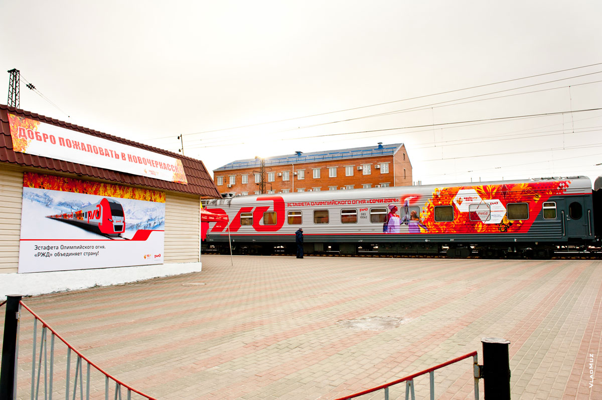 Фото рекламного баннера на стене, приветствующего в Новочеркасске эстафету Олимпийского огня