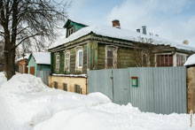 Фото старого деревянного дома в Сергиевом Посаде с резным карнизом на крыше и красивыми навершиями в наличниках на окнах