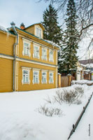 Фото желтого деревянного дома в Сергиевом посаде с декоративными резными наличниками на окнах
