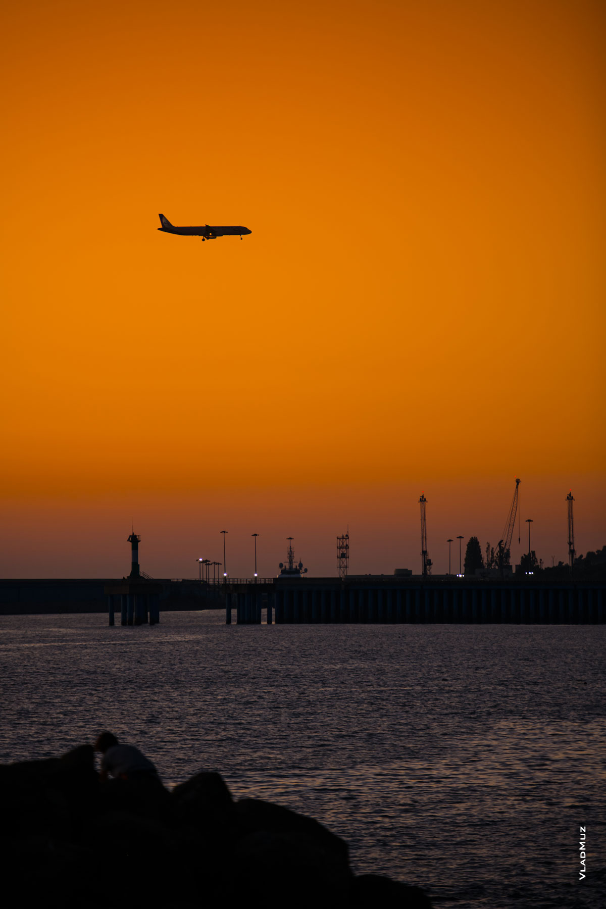 Фото самолета на фоне заката над Имеретинским морским портом в Адлере (Сочи)