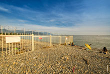 Фото металлического забора на границе пляжа «Бархатные сезоны» в Адлере и началом приграничной полосы с Абхазией и устьем реки Псоу