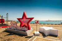 Фото большой красной звезды и букв «9 Мая. С Днем Победы» на фоне моря