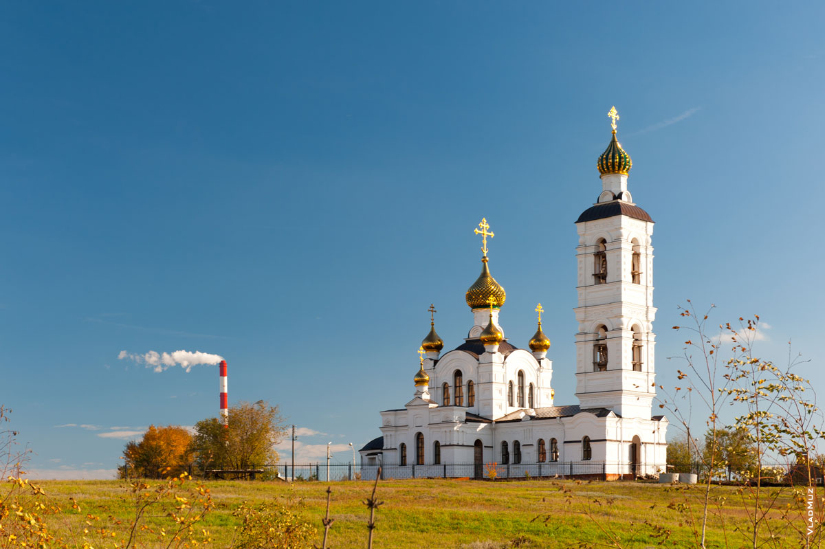 Труба ТЭЦ и Свято-Ильинский храм в Волгодонске на фоне синего неба
