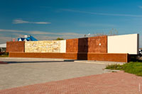 За стелой установлены украшенные рельефными рисунками плиты, на которых показаны главные стройки Волгодонска
